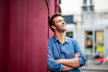 handsome older man smiling with arms crossed in city