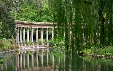 La Naumachie du Parc Monceau, classical colonnade (Naumachia) and pond with water reflections. Paris, France.