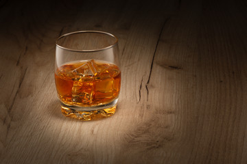 A glass of whiskey on the rocks.  Space for text.