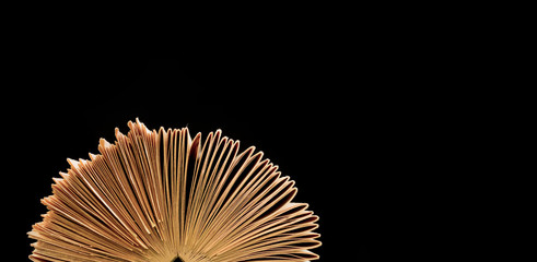 Abstract circular folded old physical  book from top view on isolated black background 