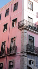 Naklejka premium Traditional Portuguese apartments, painted pink, taken on a sunny summer day in Lisbon.