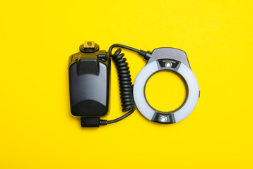 Ring flash on the camera on yellow background, top view
