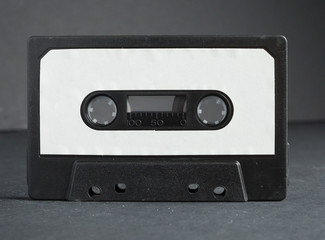 an Old retro audio tape with a blank label for mock up, typography or graphics isolated on a white background. nostalgic 1980s music audio cassette. obsolete media format.