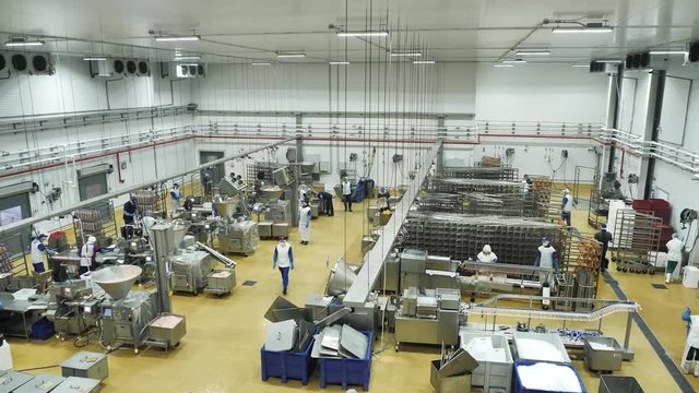Interior of meat processing plant with equipment and workers in uniform