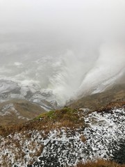 The majestic arctic Gullfoss waterfall landscape located in the canyon of the Hvítá river on the Golden Circle Route in Iceland on a foggy autumn/winter day: Scenic cascades & cliffs with ice