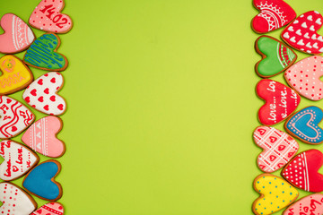 Gingerbread hearts festive on Valentine's Day. Delicious and sweet, covered with icing with a beautiful pattern, handmade. Frame. Border.
