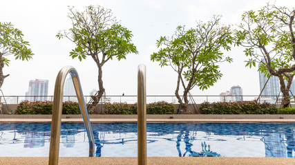 Handrails at border of swimming pool with wavy water