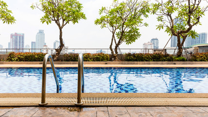 Handrails at border of swimming pool with wavy water