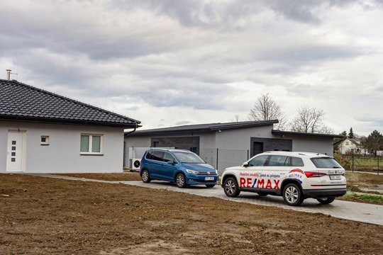 The SUV cars of the ReMax real estate company after successful sale of newly built bungalow house by a young family