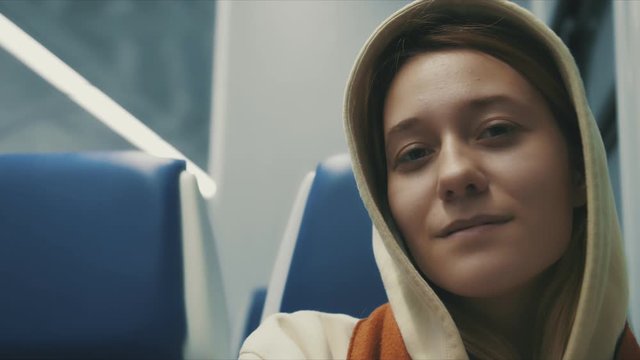 Portrait of attractive smiling girl in train and smiling transport young slow motion