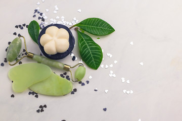 Facial and body stone massage instruments and organic soap  on light background