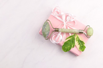 Facial and body stone massage instruments and giftbox on light background
