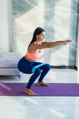 Young woman during her fitness workout at home with rubber resistance band