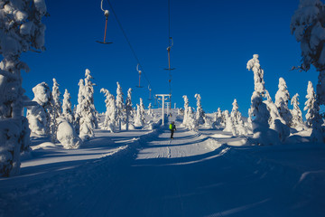 Beautiful vibrant aerial winter mountain view of ski resort, sunny winter day with slope, piste and...