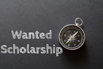 Written Wanted Scholarship words on black background with compass