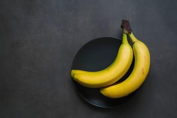 Beautiful bananas on a dark gray background. Fruit composition.