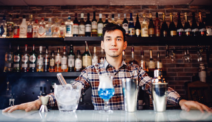 Barman mixes blue cocktail show with colorful alcoholic and smoke bar counter