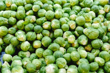 Fresh raw organic uncooked Brussels sprouts vegetables for sale at farmers market. Vegan food and healthy nutrition concept. Top view stock photo Brussels sprouts as food background.