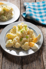 Potato salad with egg and mayonnaise on wooden background