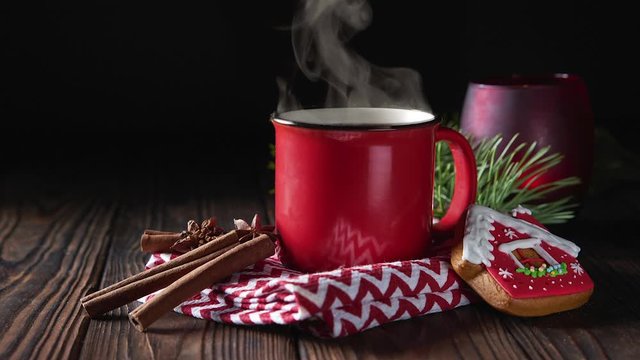 Cinemagrah loop. Hot chocolate in red mug with cinnamon and gingerbread on wooden background