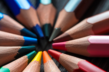 Fototapeta premium colored pencils in the center of the table lie in a circle