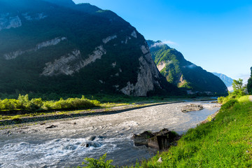 Fototapeta na wymiar High green mountains of the Caucasus, view of the fast river, Georgia