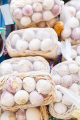 Fresh raw organic garlic in baskets as a background. Young garlic for sale at farmers market or shop. Stock photo garlic as a food background.