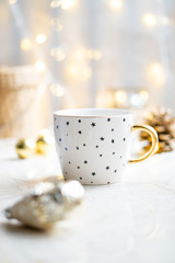 Cozy winter holiday decoration, Christmas lights and coffee cup with decor details, real home