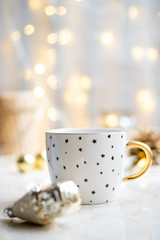 Cozy winter holiday decoration, Christmas lights and coffee cup with decor details, real home