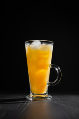  glass of fresh orange juice with ice on a black background with a place for inscription