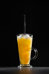  glass of fresh orange juice with ice on a black background with a place for inscription