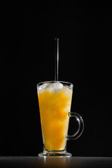  glass of fresh orange juice with ice on a black background with a place for inscription