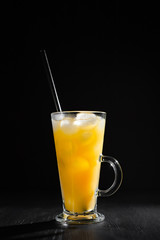  glass of fresh orange juice with ice on a black background with a place for inscription
