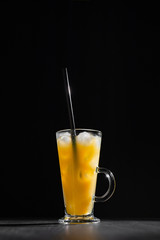  glass of fresh orange juice with ice on a black background with a place for inscription
