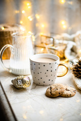 Cozy winter holiday decoration, Christmas lights and coffee cup with decor details, real home