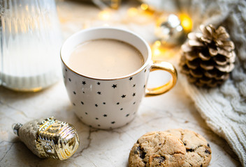 Cozy winter holiday decoration, Christmas lights and coffee cup with decor details, real home