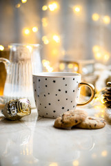 Cozy winter holiday decoration, Christmas lights and coffee cup with decor details, real home