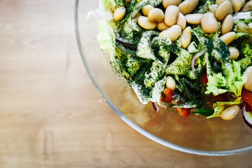 Salad with tomatoes, onions, beans, capsicium on a wooden background. Healthy food. 