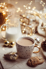 Cozy winter holiday decoration, Christmas lights and coffee cup with decor details, real home