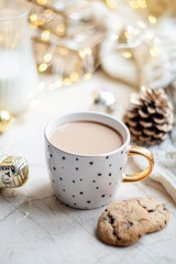 Cozy winter holiday decoration, Christmas lights and coffee cup with decor details, real home
