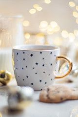 Cozy winter holiday decoration, Christmas lights and coffee cup with decor details, real home