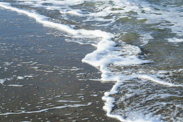 Low tide and stormy weather at  beach near the Hague, the Netherlands, featuring blue skies and waves. North Sea natural background in January.