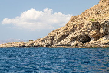 Fototapeta na wymiar View from a motor boat on the mediterranean sea at the rocky coastline near Stegna on the eastside of Greek island Rhodes