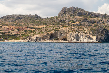 View from a motor boat on the mediterranean sea at the rocky coastline near Stegna on the eastside of Greek island Rhodes