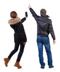 Back view of couple in winter jacket photographed on a mobile phone in winter jacket.