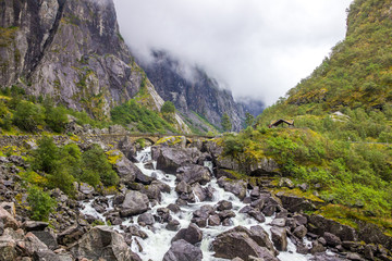 rocks in a rushing mountain river during a rainy day in Norway
