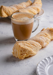 homemade bread covered with sugar and cup of coffee on white background