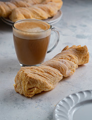 homemade bread covered with sugar and cup of coffee on white background