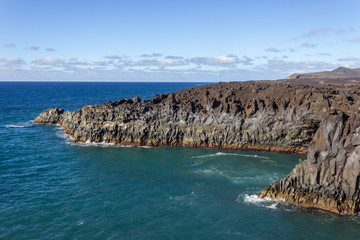 Rocky coastline Los Hervideros in the south west of canary island Lanzarote with rough sea, lava caves and multi colored volcanic rocks