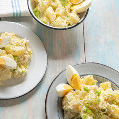 Potato salad with egg and mayonnaise on wooden background